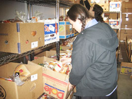 A young woman helping gather food for the needy at a Tomchei shabbas warehouse