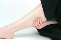 Woman massaging the cramp she has in her leg